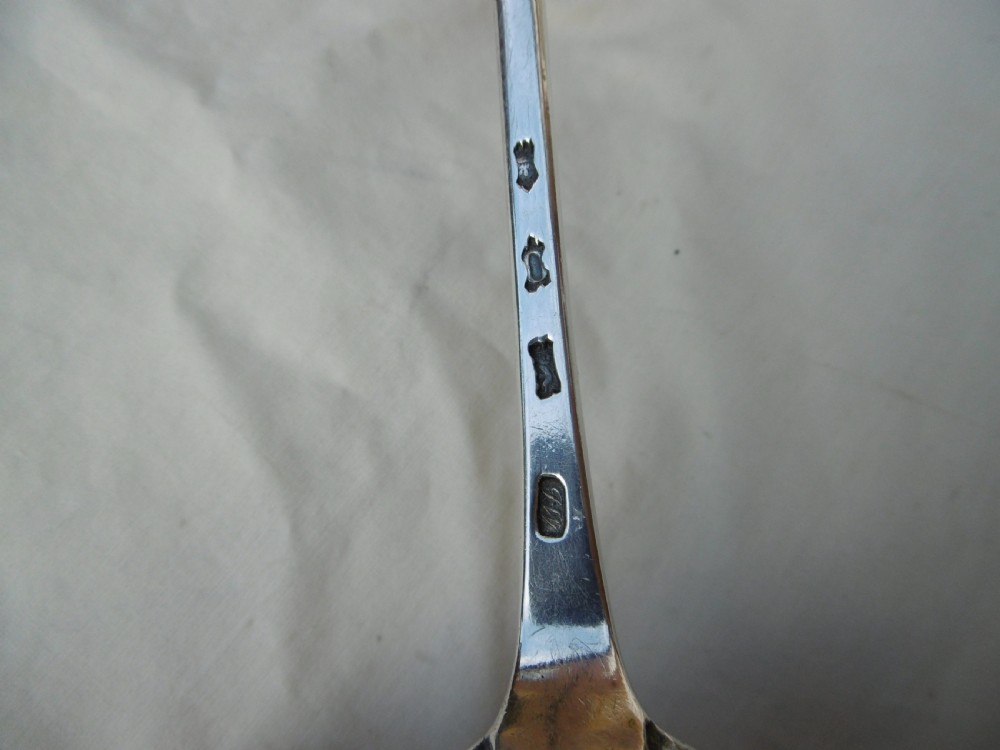 A mid-18th-century Georgian sterling silver stuffing spoon showing maker hallmarks along the slender stem and a polished oval bowl. View IV