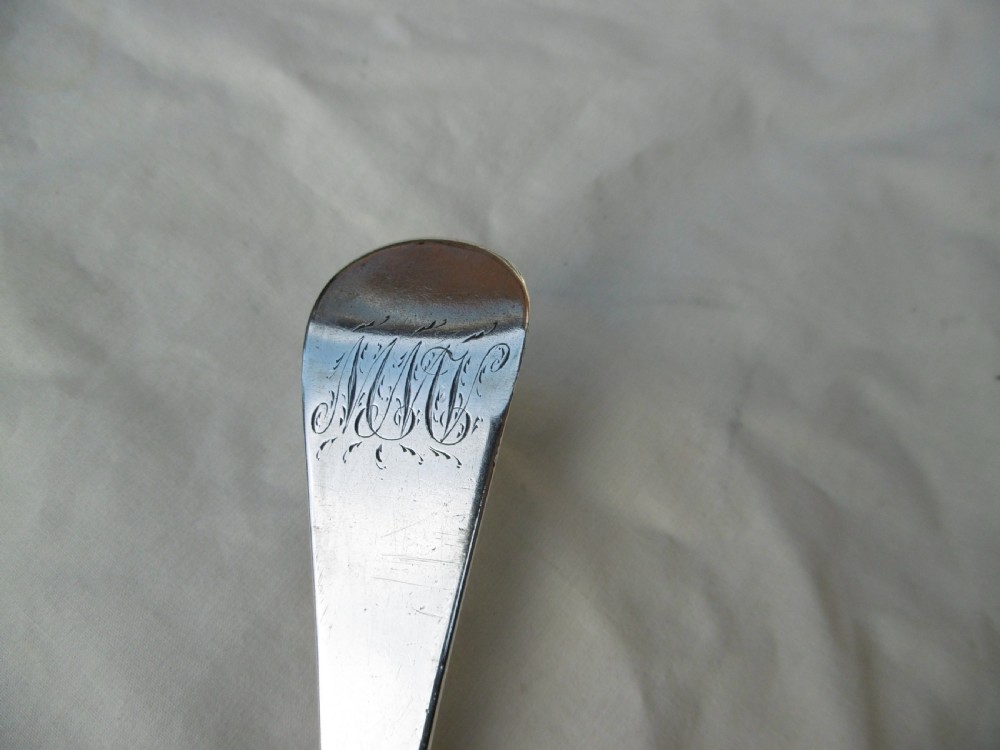 A mid-18th-century Georgian sterling silver stuffing spoon showing maker hallmarks along the slender stem and a polished oval bowl. View V