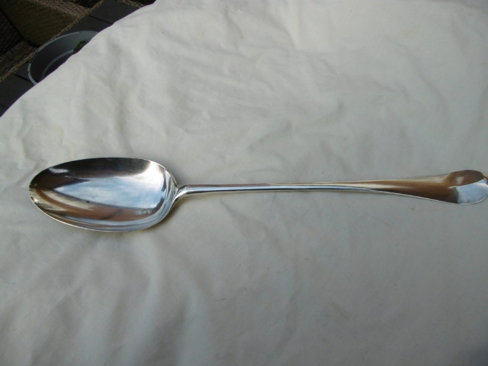 A mid-18th-century Georgian sterling silver stuffing spoon showing maker hallmarks along the slender stem and a polished oval bowl. View VI
