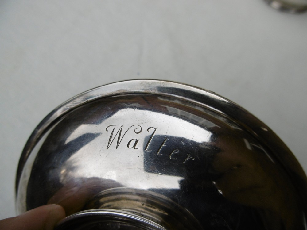 A circular Georgian sterling silver paten dish with a moulded rim resting on a short foot ring. View IV