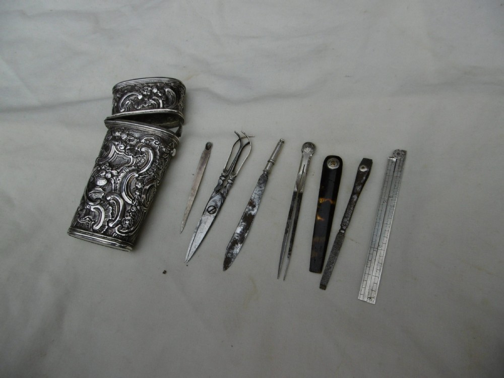 An eighteenth-century silver etui decorated with repousse relief patterns, shown with its hinged top open to reveal interior slots and fitted tools. View III