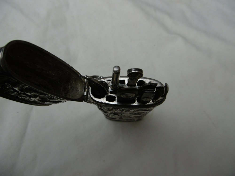 An eighteenth-century silver etui decorated with repousse relief patterns, shown with its hinged top open to reveal interior slots and fitted tools. View IV