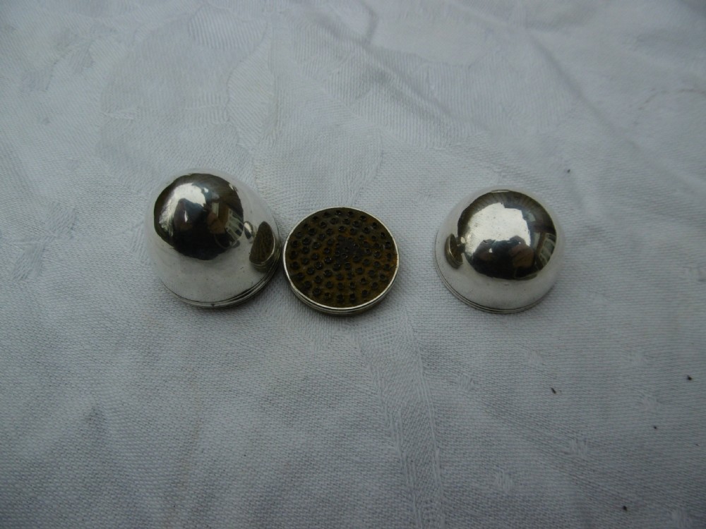 A three-piece antique Georgian sterling silver acorn-shaped nutmeg grater shown unscrewed alongside its circular steel grater plate.