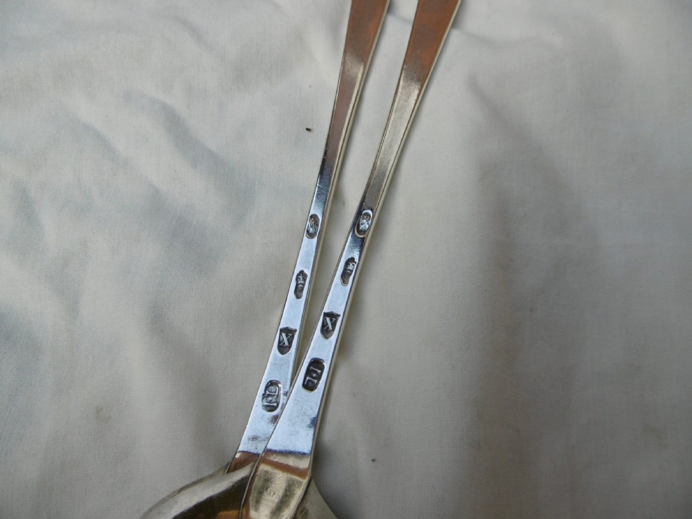 A pair of 18th-century Irish sterling silver basting spoons with hooked terminals presented inside a black velvet and silk lined case. View IV