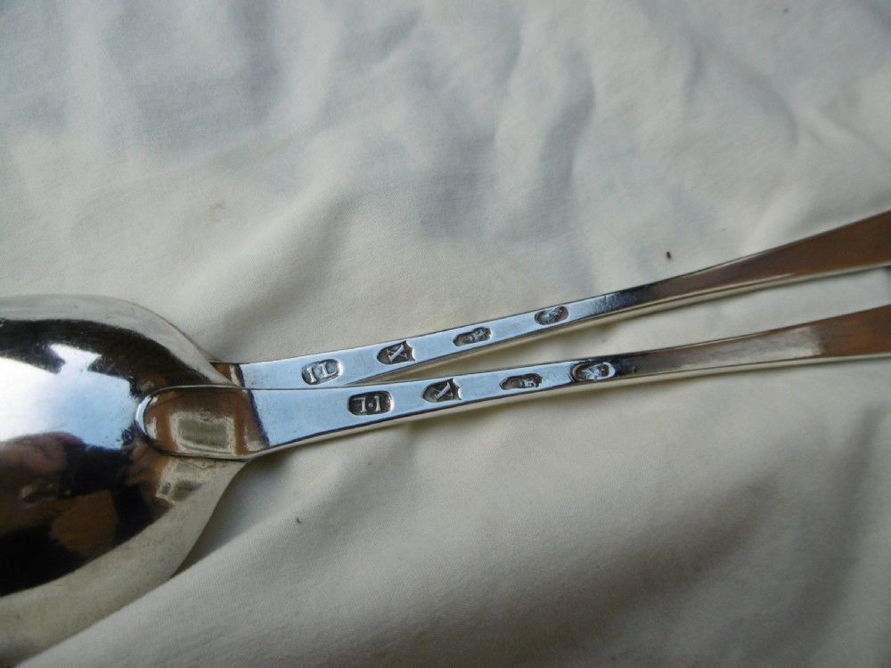 A pair of 18th-century Irish sterling silver basting spoons with hooked terminals presented inside a black velvet and silk lined case. View V