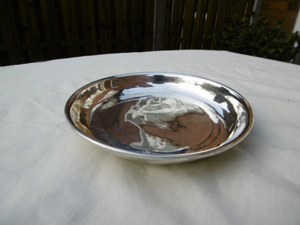 A shallow, circular Georgian silver dish paten featuring a moulded rim and a polished finish.