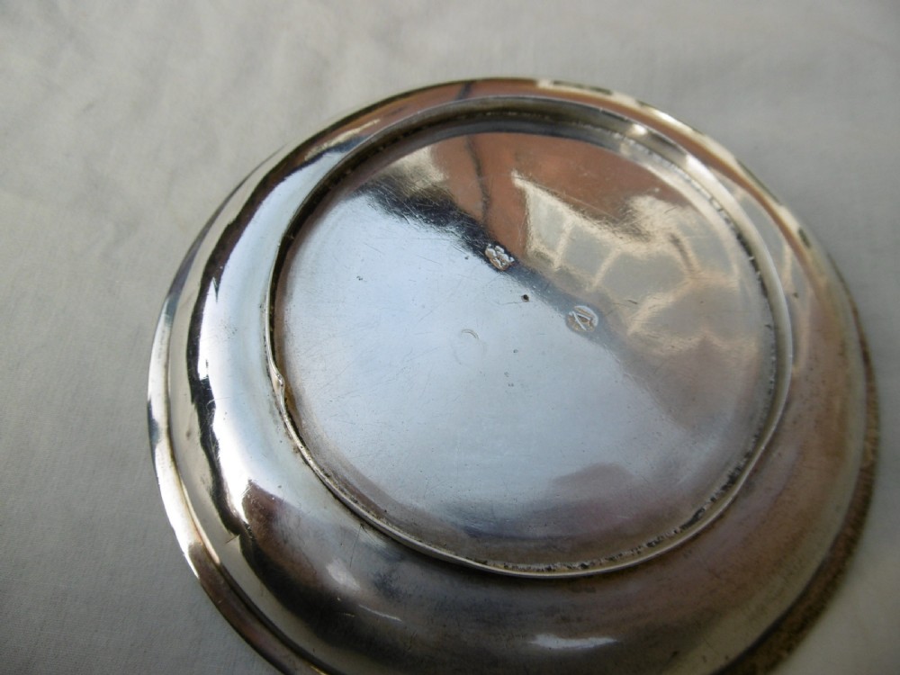 A shallow, circular Georgian silver dish paten featuring a moulded rim and a polished finish. View II