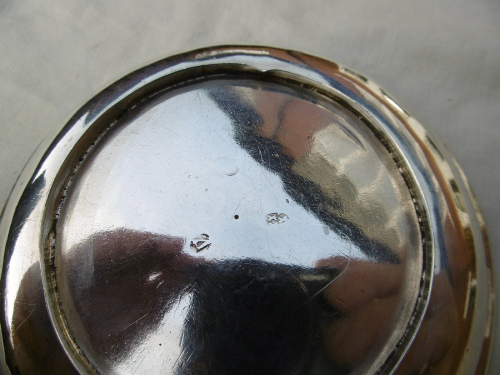 A shallow, circular Georgian silver dish paten featuring a moulded rim and a polished finish. View III