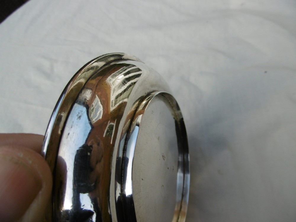 A shallow, circular Georgian silver dish paten featuring a moulded rim and a polished finish. View IV