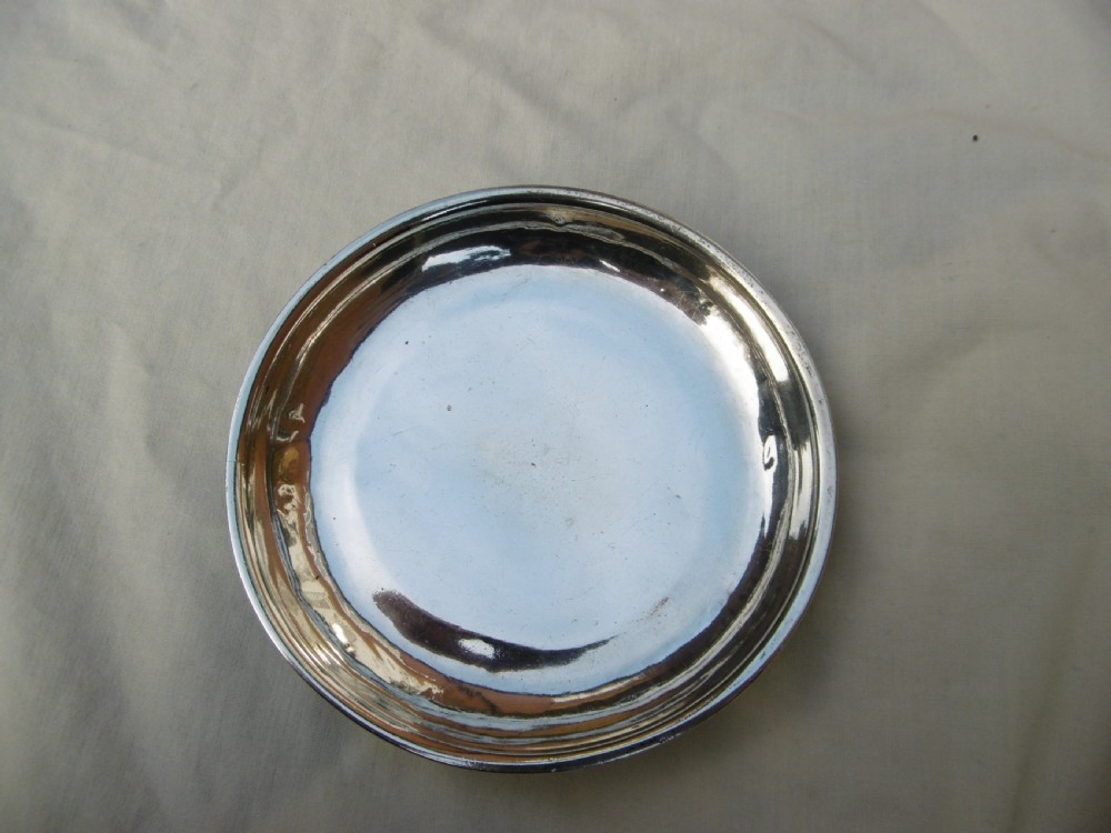 A shallow, circular Georgian silver dish paten featuring a moulded rim and a polished finish. View V