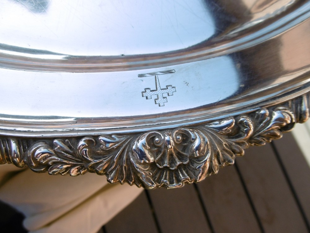 An oval Georgian sterling silver platter featuring a cast shell and gadrooned border with an engraved heraldic crest. View III