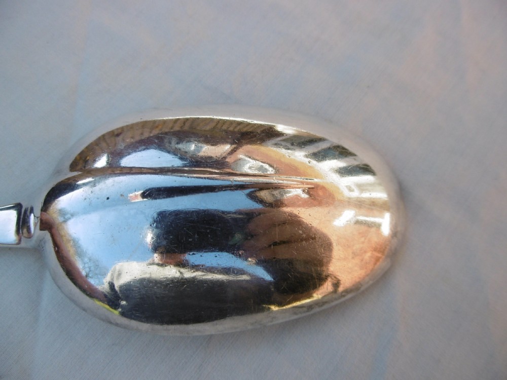 A George I Britannia standard silver basting spoon featuring a long tapered handle and an oval bowl with a rat-tail joint. View IV