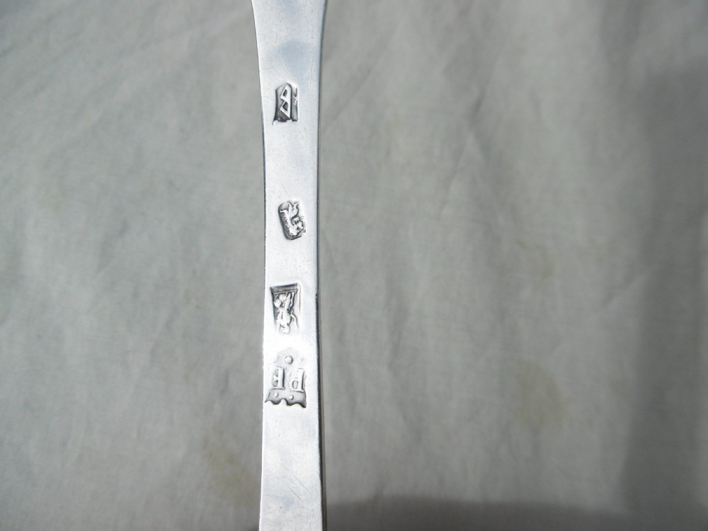 An antique silver William III trefid spoon with stamped hallmarks along the flat stem, engraved initials on the notched terminal, and a rat-tail bowl attachment. View II