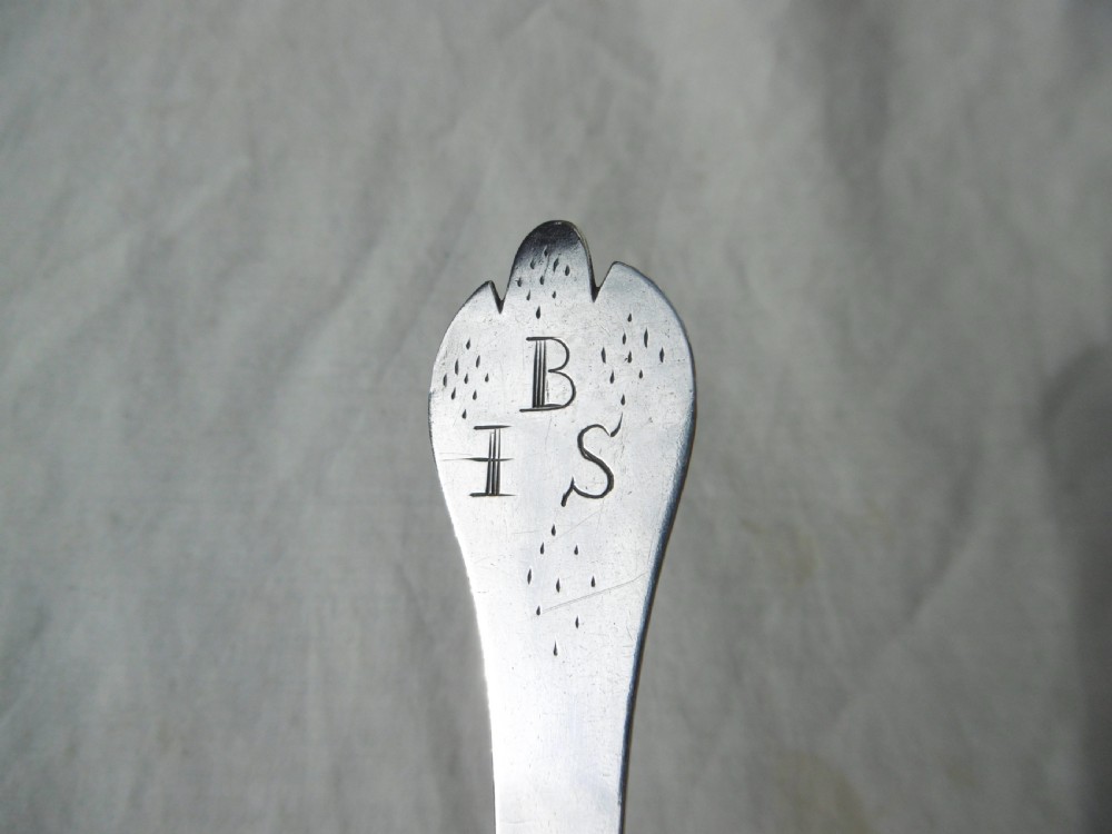 An antique silver William III trefid spoon with stamped hallmarks along the flat stem, engraved initials on the notched terminal, and a rat-tail bowl attachment. View IV