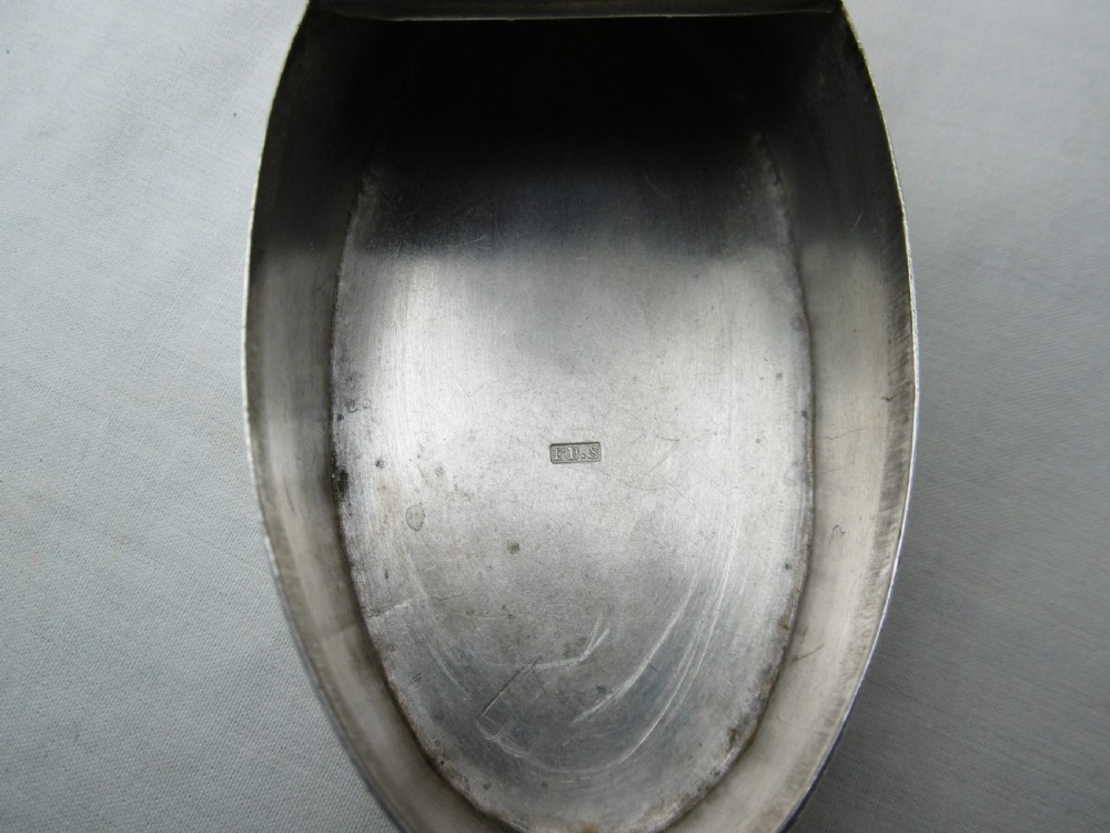 An oval Georgian silver snuff box decorated with bright-cut engraving and an armorial coat of arms. View III