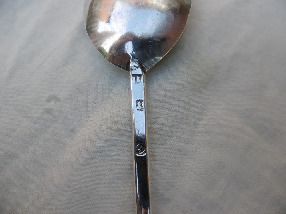 A sterling silver spoon featuring a wide fig-shaped bowl, a slim straight stem, and a rounded seal top terminal. View III