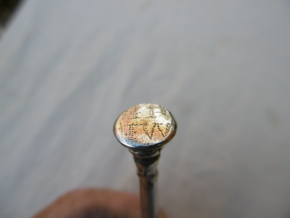 A sterling silver spoon featuring a wide fig-shaped bowl, a slim straight stem, and a rounded seal top terminal. View V