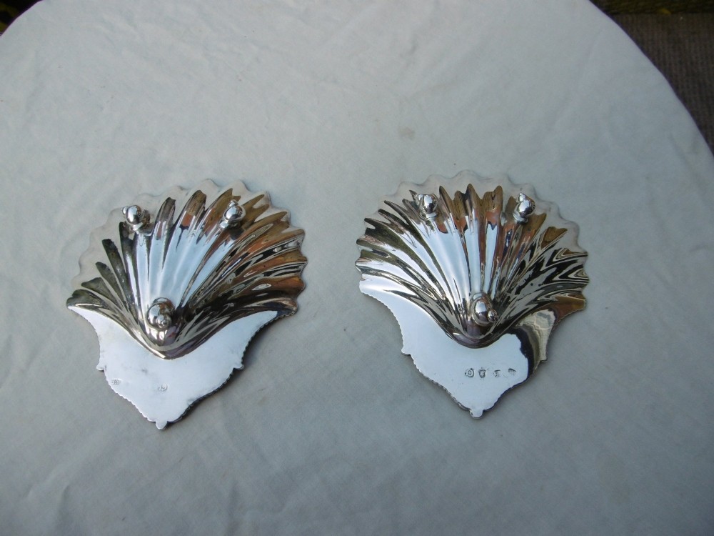 A pair of 18th-century sterling silver butter dishes shaped like scallop shells with fluted interiors and engraved handles. View III