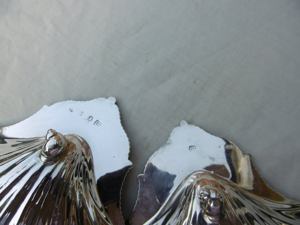 A pair of 18th-century sterling silver butter dishes shaped like scallop shells with fluted interiors and engraved handles. View IV