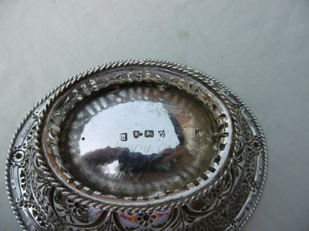An oval 18th-century sterling silver basket featuring pierced openwork, an embossed rim, and a twisted swing handle. View III