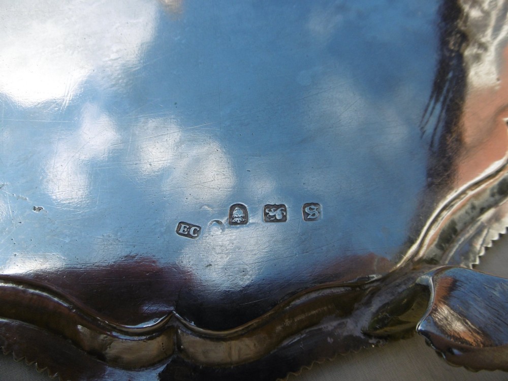 A circular Georgian sterling silver salver featuring a scalloped gadrooned rim and a central armorial crest engraving. View III