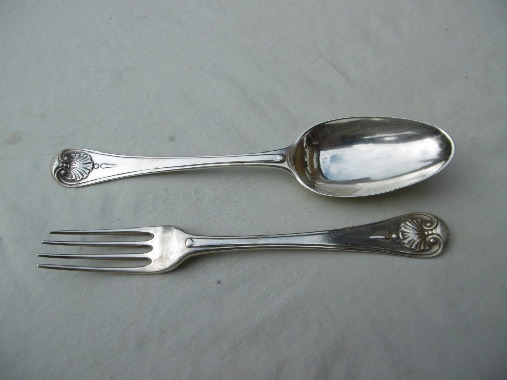 A mid-eighteenth-century sterling silver spoon and four-tined fork crafted in the Hanoverian Thread, Shell and Drop pattern.