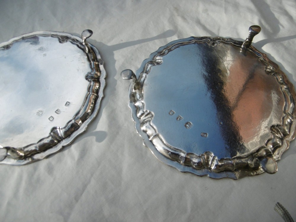A pair of round George II sterling silver waiters with piecrust borders, resting on small feet, each central panel engraved with a stag crest. View III
