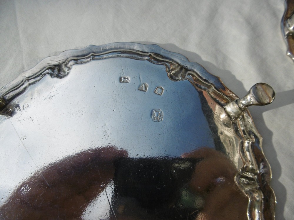 A pair of round George II sterling silver waiters with piecrust borders, resting on small feet, each central panel engraved with a stag crest. View IV