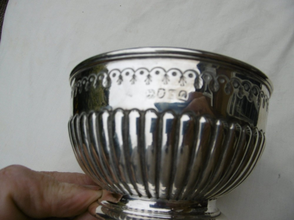A George III sterling silver footed bowl featuring a fluted lower body, an engraved foliate upper border, and a stepped circular base. View III