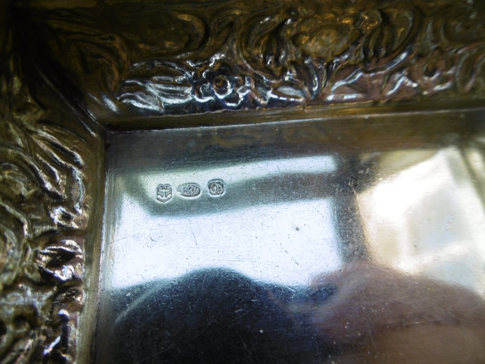 A rectangular William IV sterling silver table snuff box featuring heavily chased floral borders and an engine-turned lid with a plain central cartouche. View VIII