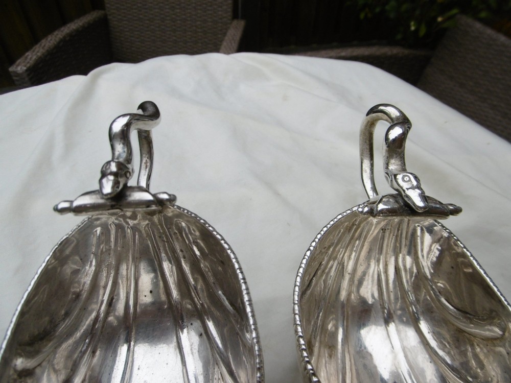 A pair of 18th-century Georgian sterling silver sauce boats featuring fluted shell bodies, serpent handles, and pedestal bases. View II