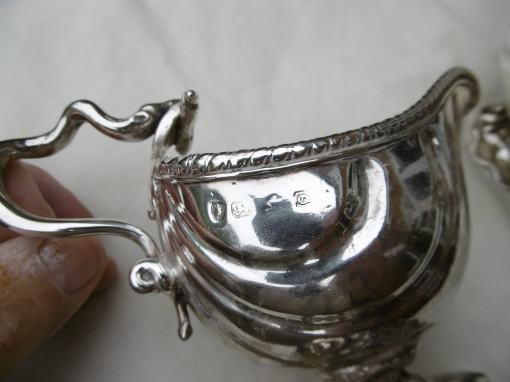 A pair of 18th-century Georgian sterling silver sauce boats featuring fluted shell bodies, serpent handles, and pedestal bases. View IV
