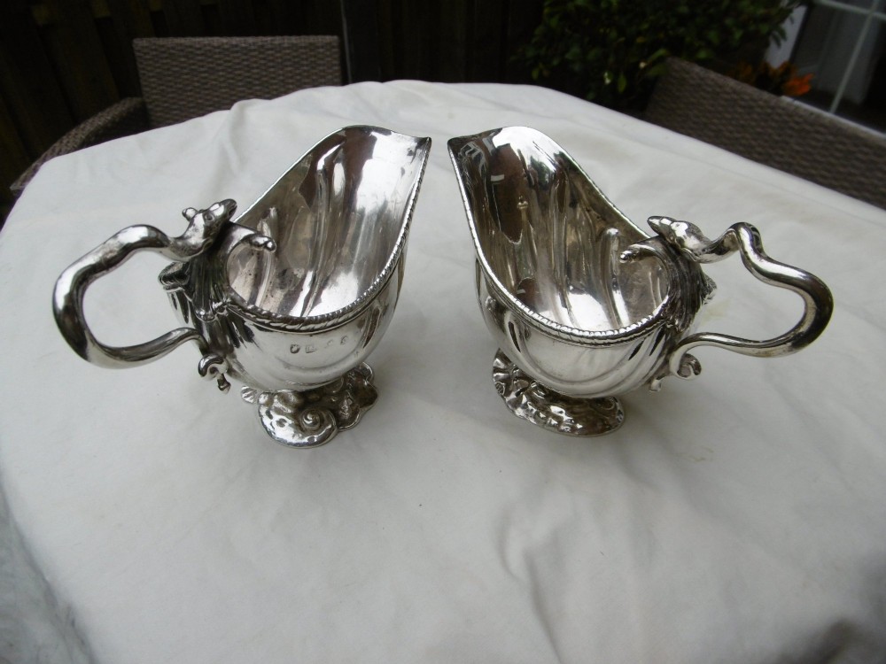 A pair of 18th-century Georgian sterling silver sauce boats featuring fluted shell bodies, serpent handles, and pedestal bases. View VIII