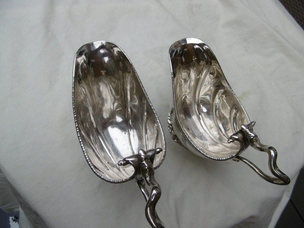 A pair of 18th-century Georgian sterling silver sauce boats featuring fluted shell bodies, serpent handles, and pedestal bases. View IX