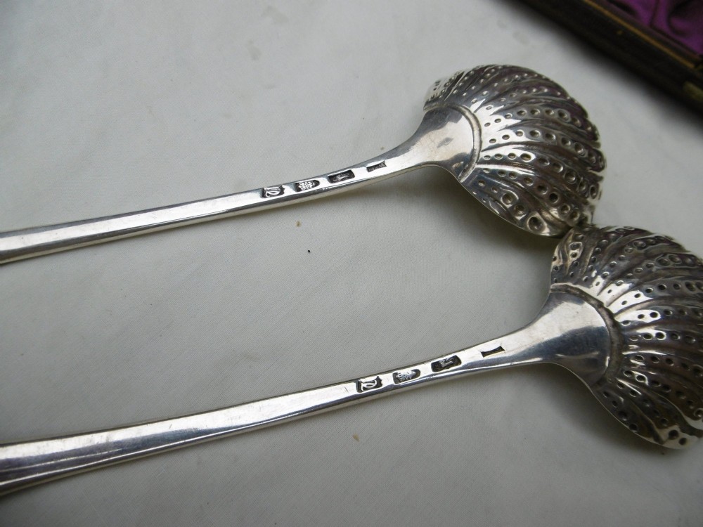 A pair of Georgian sterling silver ladles with Onslow pattern scroll handles and shell-shaped bowls resting inside a velvet-lined presentation box. View III