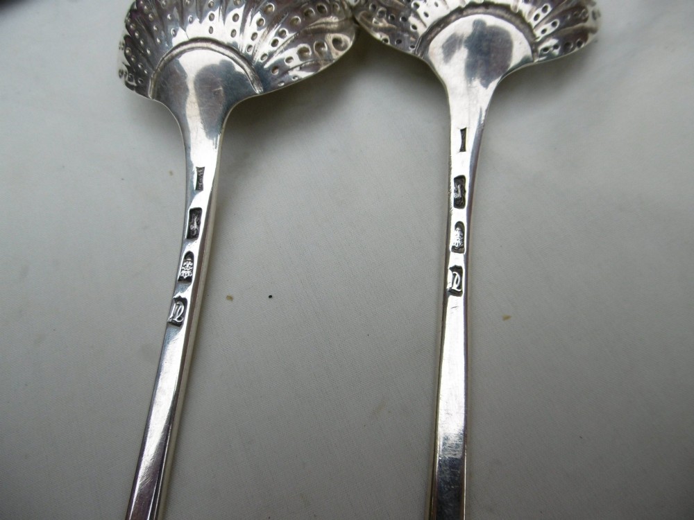 A pair of Georgian sterling silver ladles with Onslow pattern scroll handles and shell-shaped bowls resting inside a velvet-lined presentation box. View IV