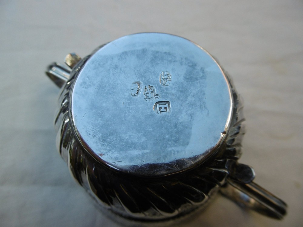 A George I Britannia standard silver porringer with twin scroll handles, fluted lower body decoration, and gadrooned banding. View II
