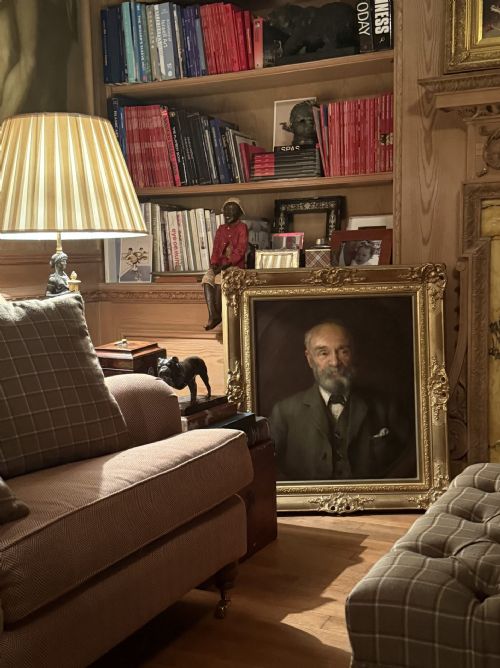 fig 1. An antique oil painting depicting a bearded gentleman wearing a suit coat, set against a dark brown oval spandrel background.