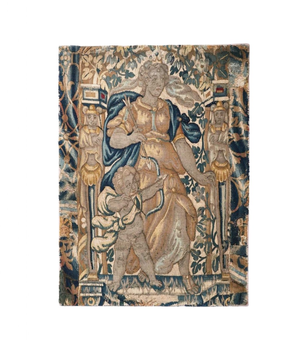 A hand-woven 17th-century Flemish tapestry fragment depicting a classical female figure holding a bow alongside a winged cherub surrounded by foliage and architectural pillars.