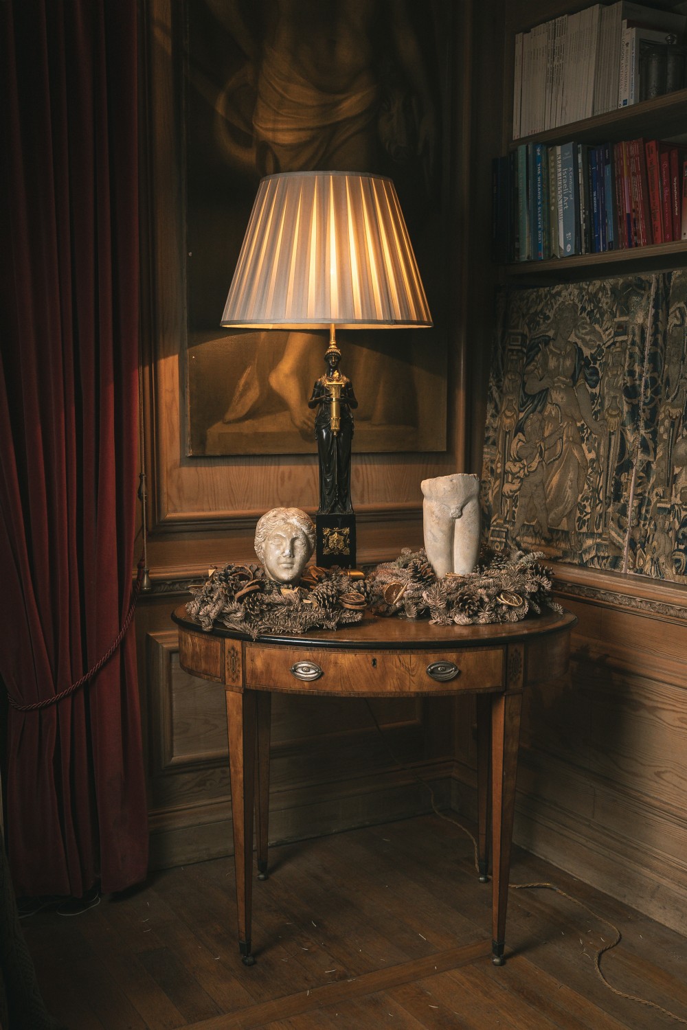 An oval satinwood writing table featuring a dark insert top, single frieze drawer with brass handles, inlaid floral panels, and tapered legs on castors. View V