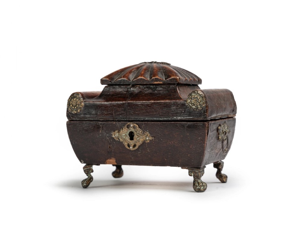 An early 19th-century dark brown leather Regency jewellery casket with fluted lid, brass rosette mounts, and claw and ball feet.