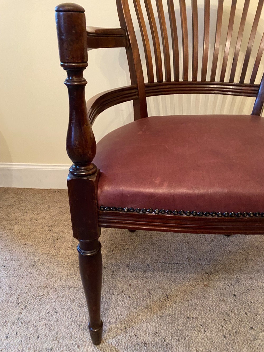A pair of mahogany club armchairs featuring vertical slat backrests, curved arms with turned supports, and reddish-brown leather upholstered seats with stud detailing. View XIII