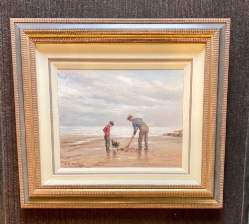 fig 1. An oil painting on canvas depicting figures and a dog on a sandy shoreline, presented in a stepped gilded and textured wooden frame.