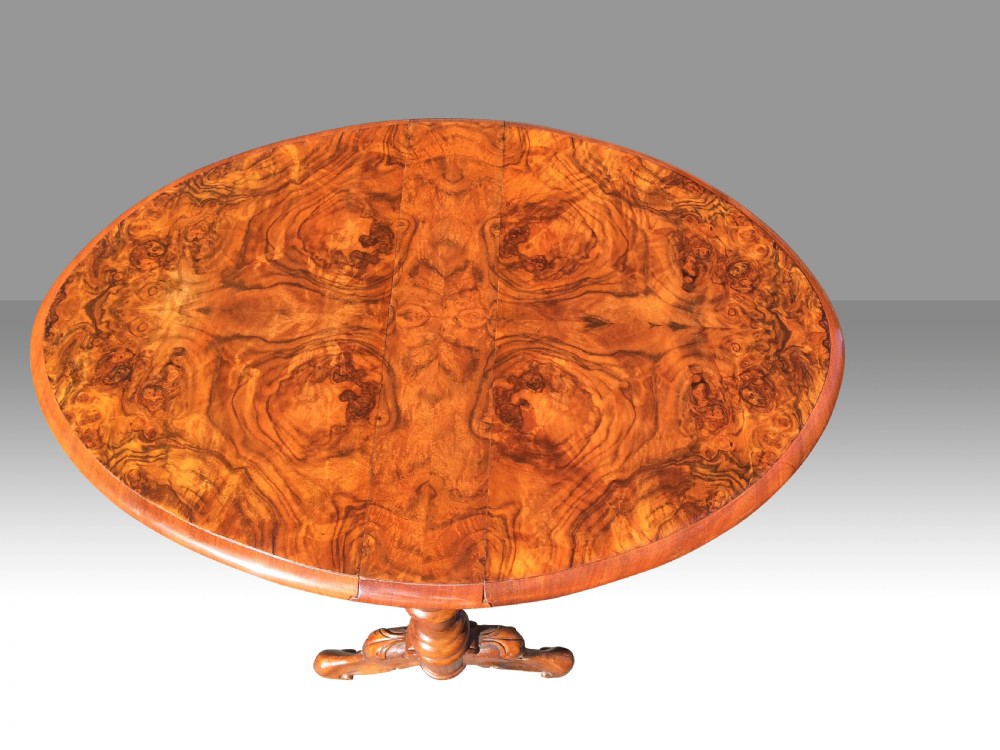 A Victorian burr walnut baby Sutherland table with folded leaves, barley-twist supports, carved feet, and ceramic castors. View IV