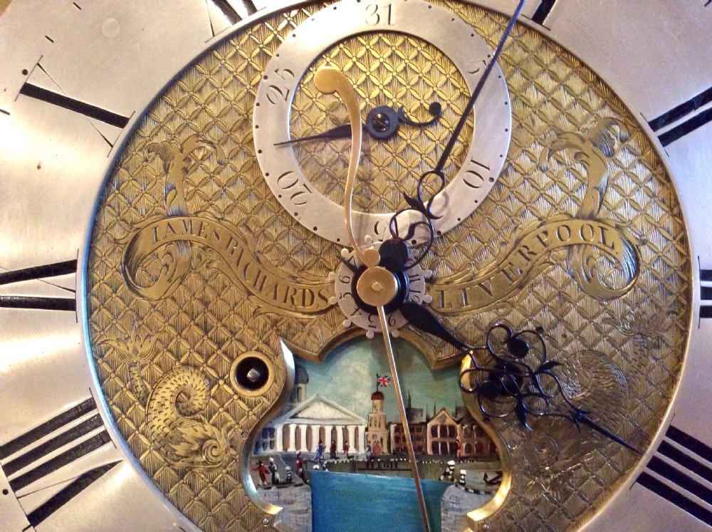 An 18th-century mahogany longcase clock featuring a swan-neck pediment, an arched dial, and flame mahogany door. View XXI