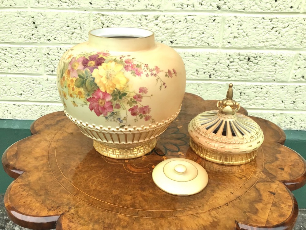 A globular Royal Worcester blush ivory pot pourri vase featuring hand-painted floral motifs, basketweave relief detail, and a pierced gilded lid. View III