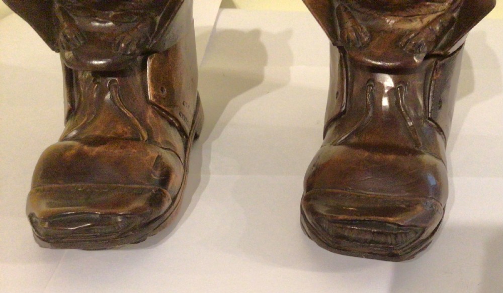 A pair of hand-carved dark brown wood inkwells shaped like cats sitting inside boots with green glass eyes. View VII
