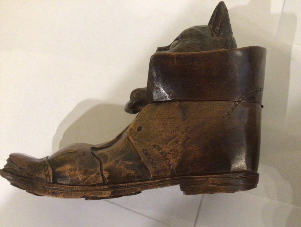 A pair of hand-carved dark brown wood inkwells shaped like cats sitting inside boots with green glass eyes. View VIII