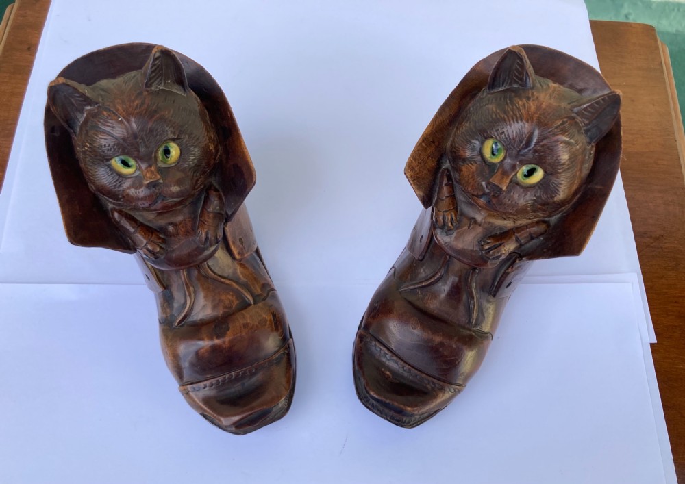 A pair of hand-carved dark brown wood inkwells shaped like cats sitting inside boots with green glass eyes. View XII
