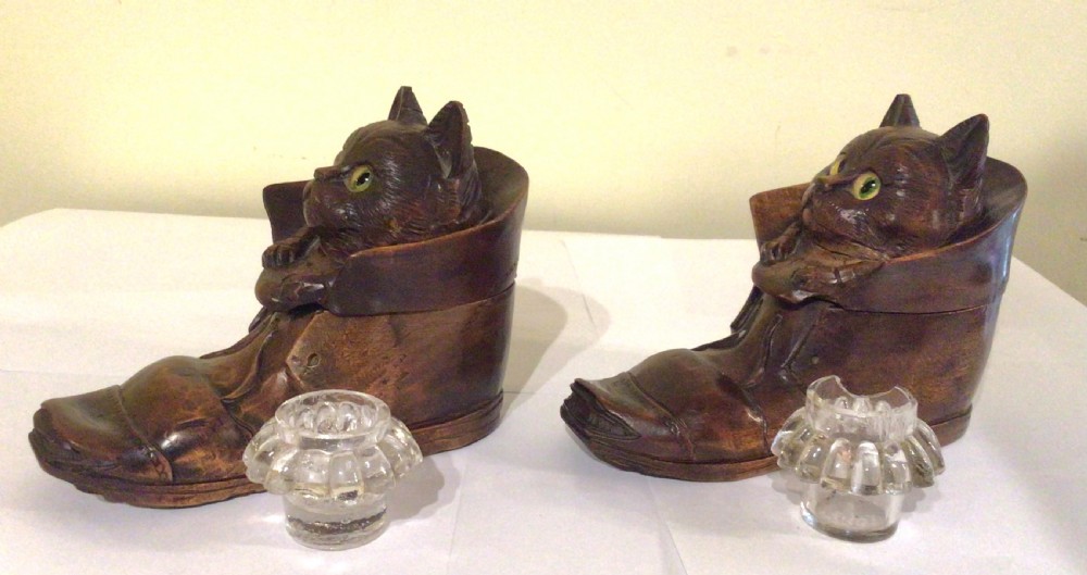 A pair of hand-carved dark brown wood inkwells shaped like cats sitting inside boots with green glass eyes. View XIII